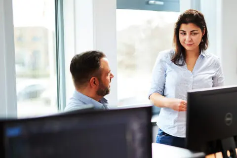 man and woman in consultation behind their laptop