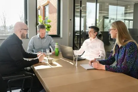 vier collega's met elkaar in overleg